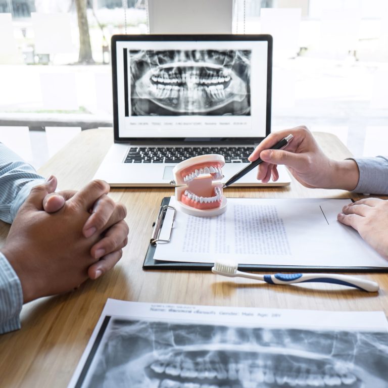 Professional,Dentist,And,Patient,Discussing,Jaw,And,Teeth,The,X-ray